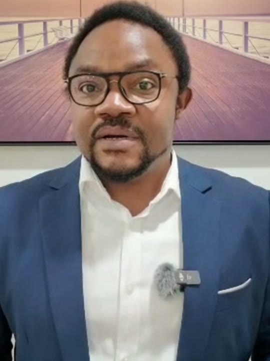 Un des ambassadeurs de la candidature, filmé dans un intérieur, costume bleu devant un tableau